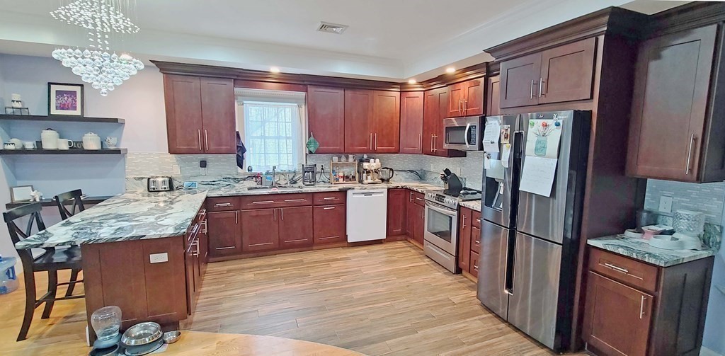 6 Sylvan Road Holbrook, MA 02343 - Photo 4 of 24 a kitchen with granite countertop stainless steel appliances a refrigerator stove top oven and sink