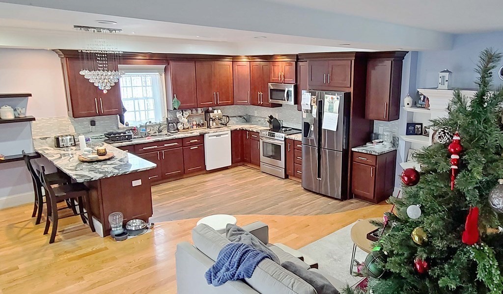 6 Sylvan Road Holbrook, MA 02343 - Photo 5 of 24 a kitchen with granite countertop wooden cabinets stainless steel appliances and window