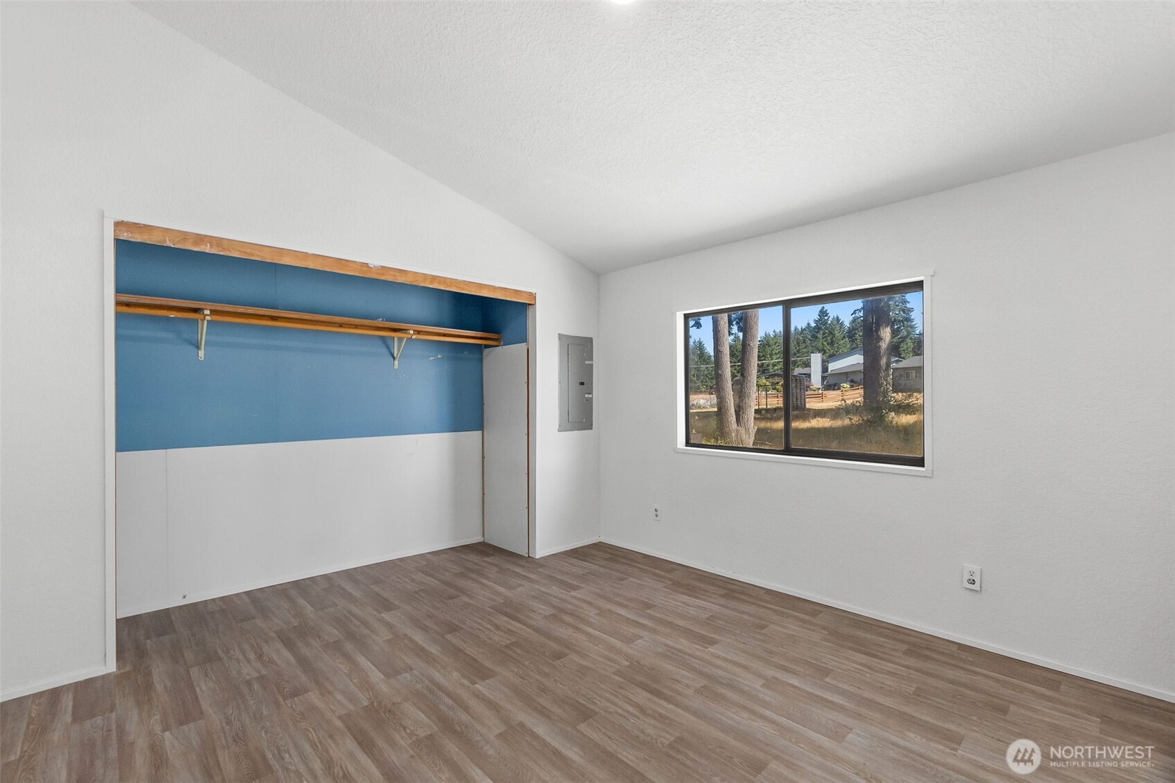 7140 191st Avenue Southwest, Unit 26 Rochester, WA 98579 - Photo 14 of 18 a view of an empty room with wooden floor and a window