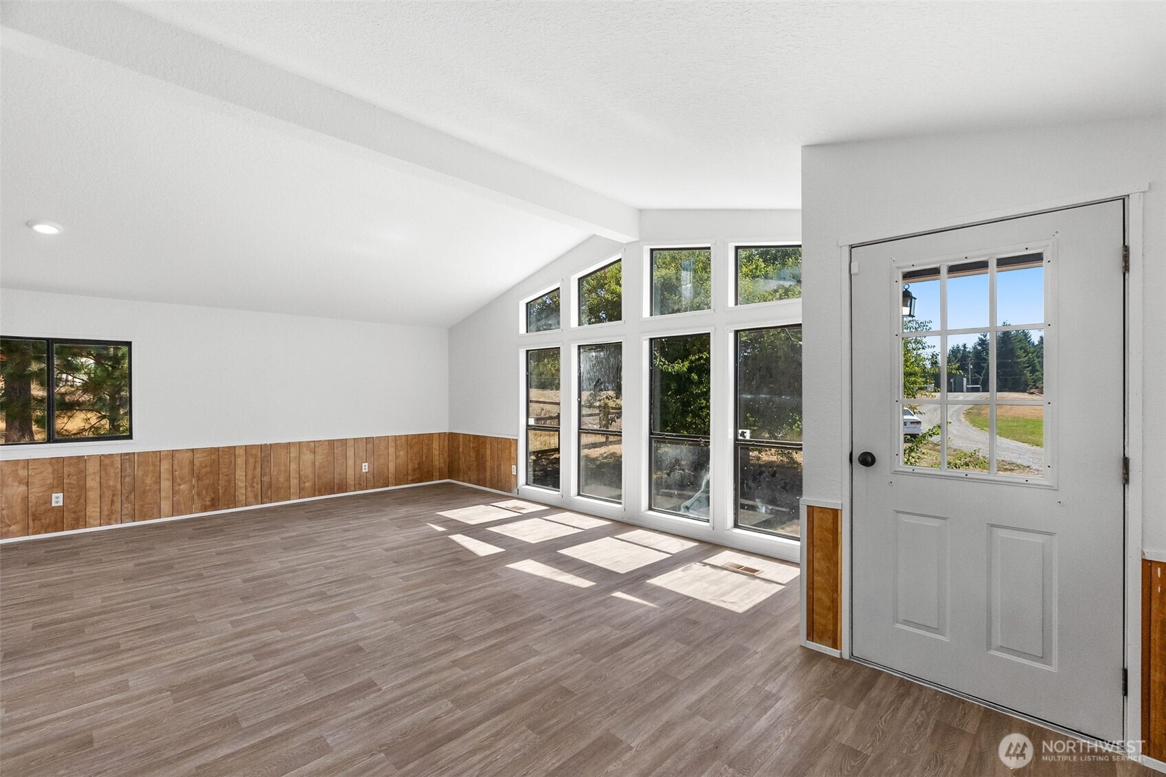 7140 191st Avenue Southwest, Unit 26 Rochester, WA 98579 - Photo 7 of 18 a view of an empty room with a window and wooden floor