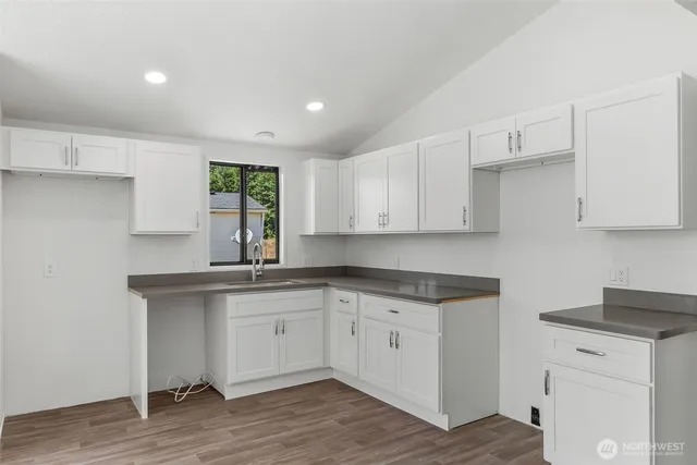 a kitchen with a sink cabinets and wooden floor