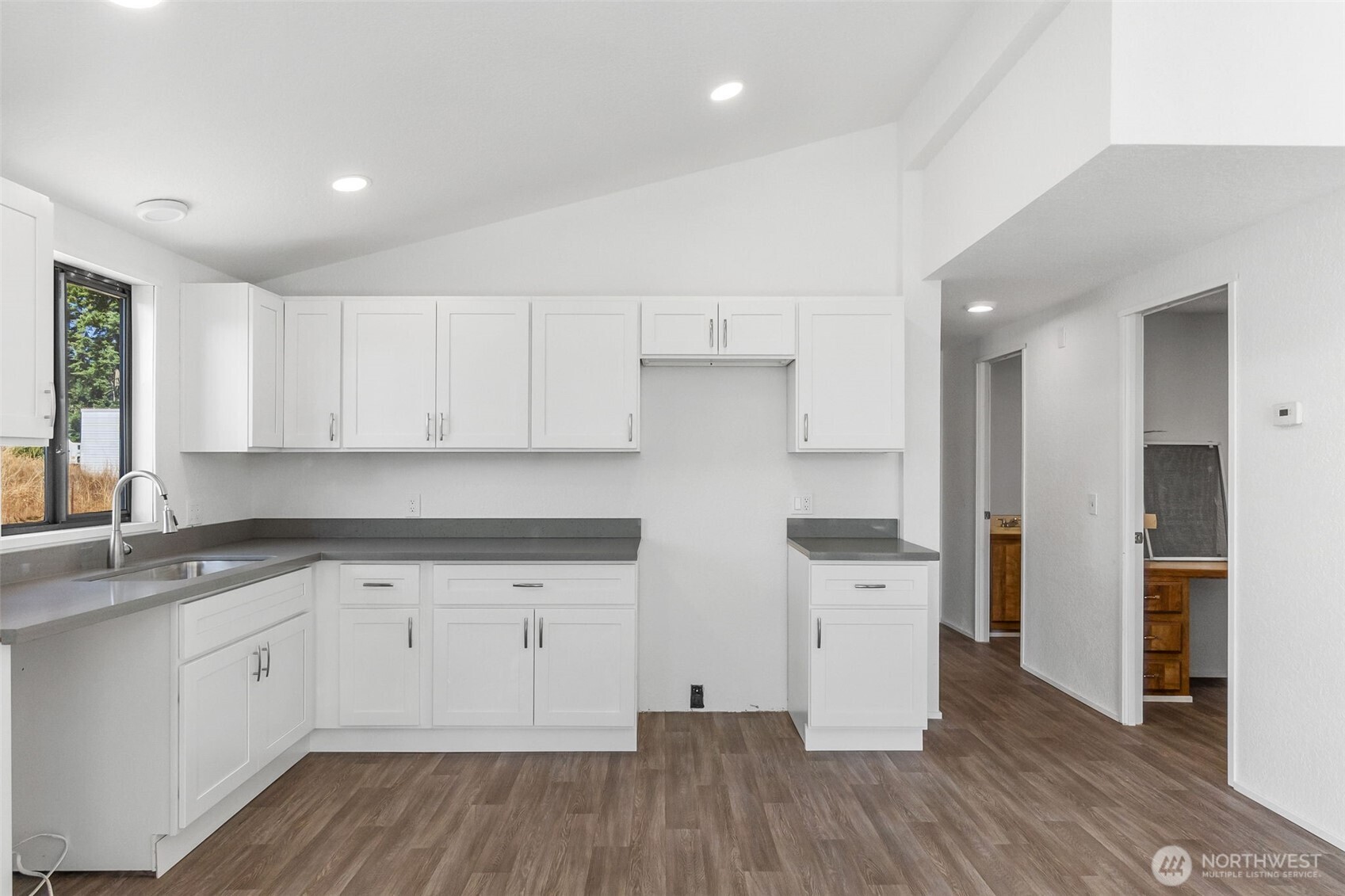 7140 191st Avenue Southwest, Unit 26 Rochester, WA 98579 - Photo 9 of 18 a kitchen with a hard wood floor white cabinets and stainless steel appliances