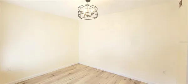 a view of a room with wooden floor and white walls