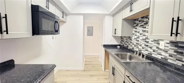 a kitchen with granite countertop a sink and a stove