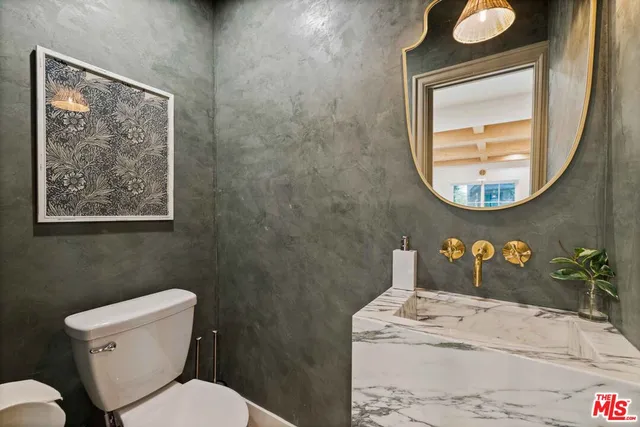 a bathroom with a toilet a sink and mirror