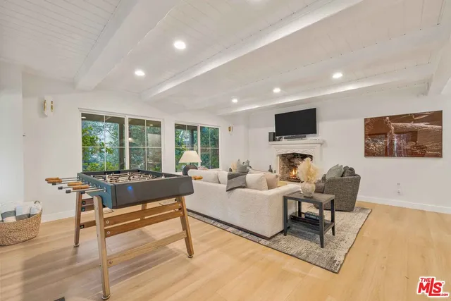 a living room with furniture fireplace and a large window