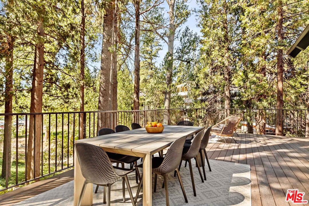 27643 West Shore Road, Unit 3 Lake Arrowhead, CA 92352 - Photo 5 of 31 a view of a patio with table and chairs and wooden floor