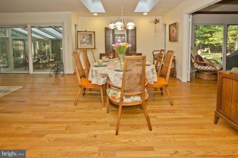 11245 Handlebar Road Reston, VA 20191 - Photo 24 of 27 a dining room with furniture a chandelier and wooden floor