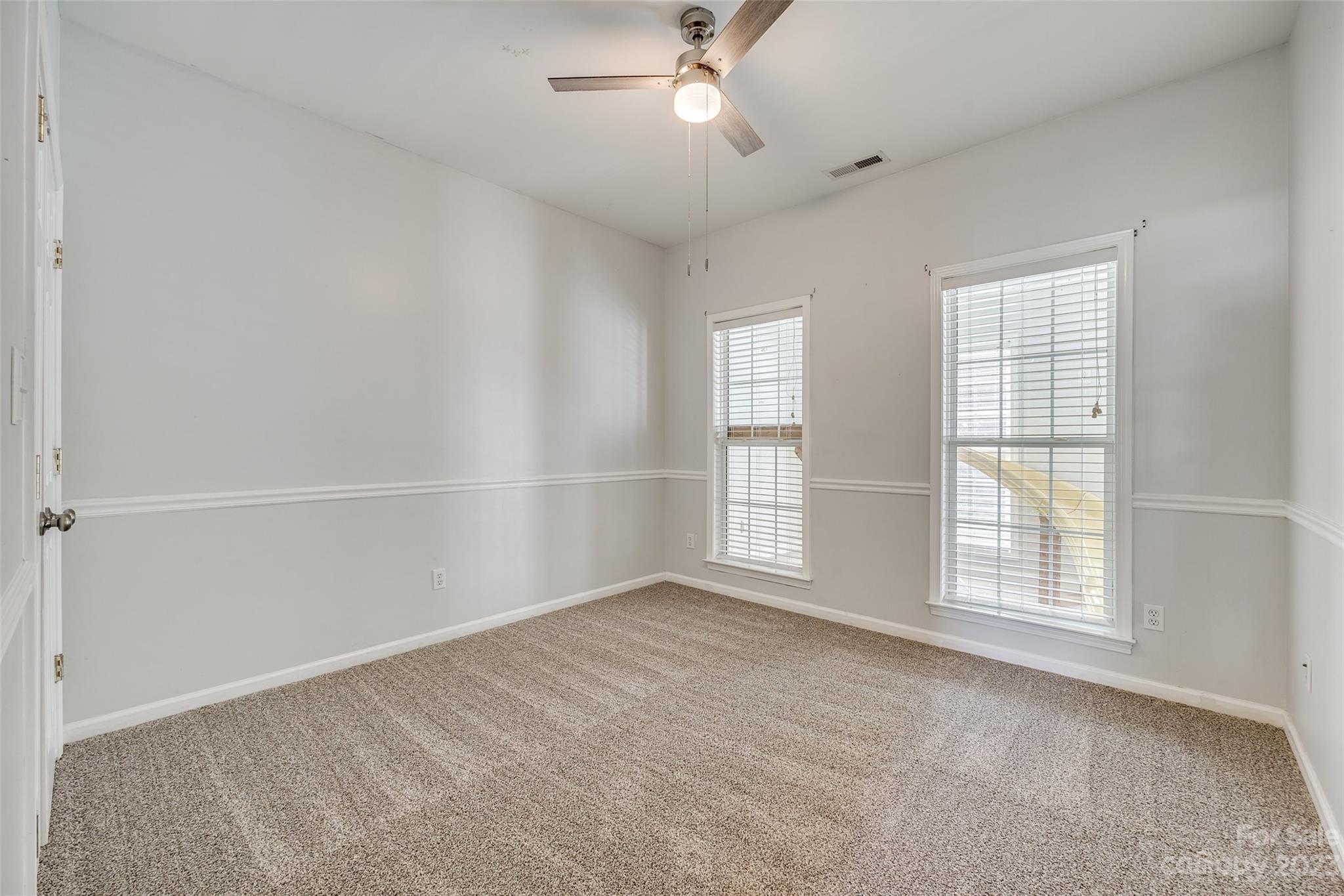1028 Needles Drive Lancaster, SC 29720 - Photo 17 of 34 an empty room with chandelier fan and windows