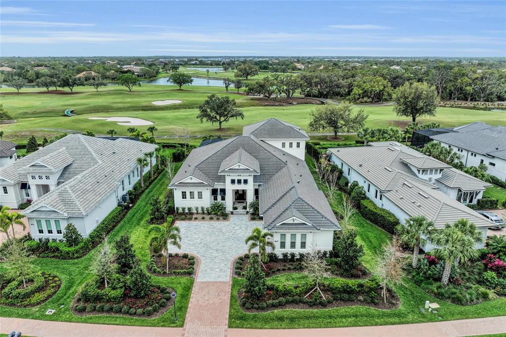 an aerial view of a house with a yard and lake view
