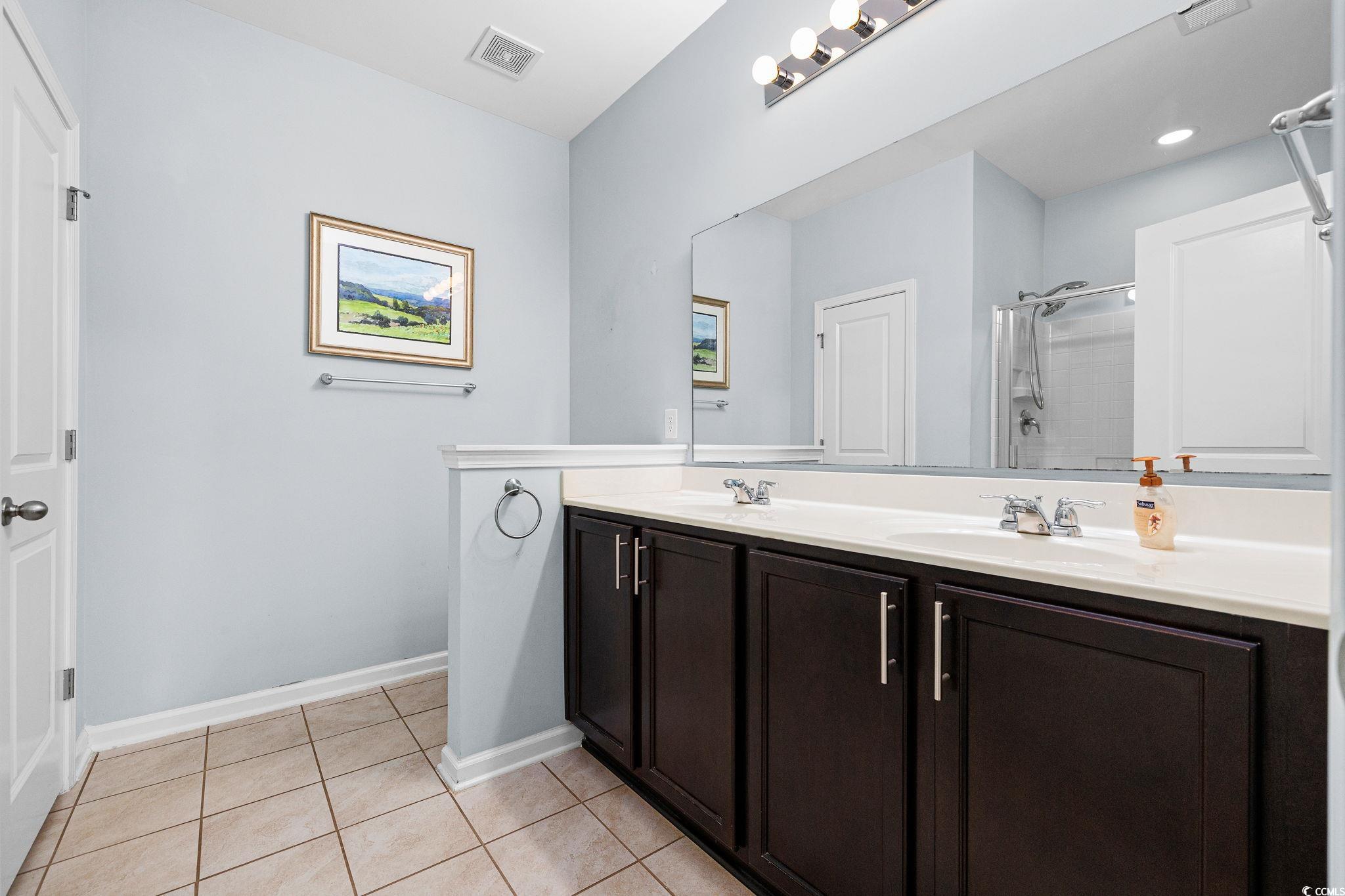 817 Arezzo Way, Unit 1001 Myrtle Beach, SC 29579 - Photo 24 of 40 Full bath with light tile patterned floors, double vanity, and a shower