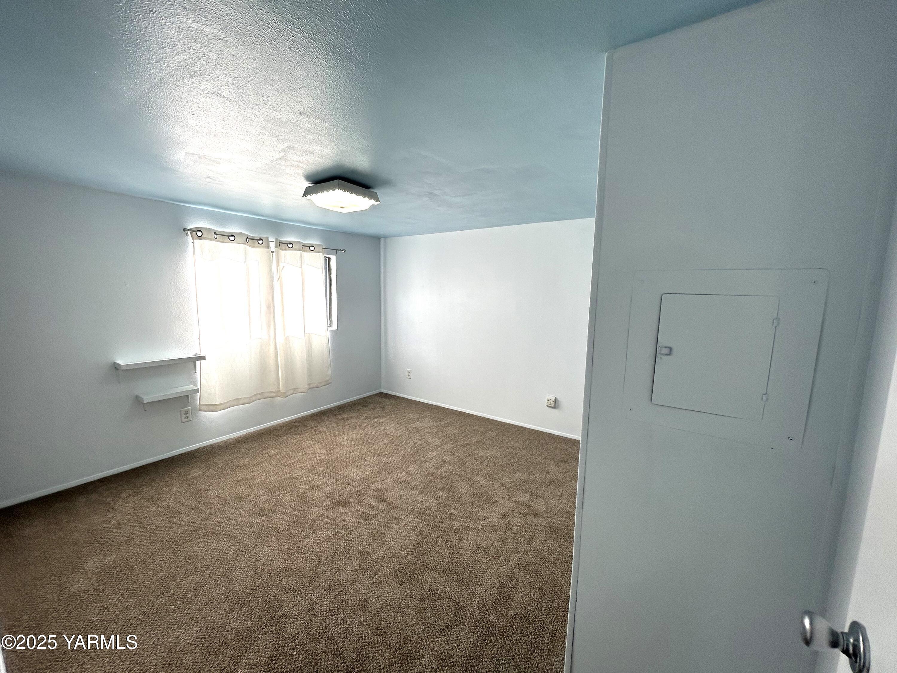 451 Pence Road, Unit 49 Yakima, WA 98908 - Photo 14 of 16 an empty room with windows and chandelier fan