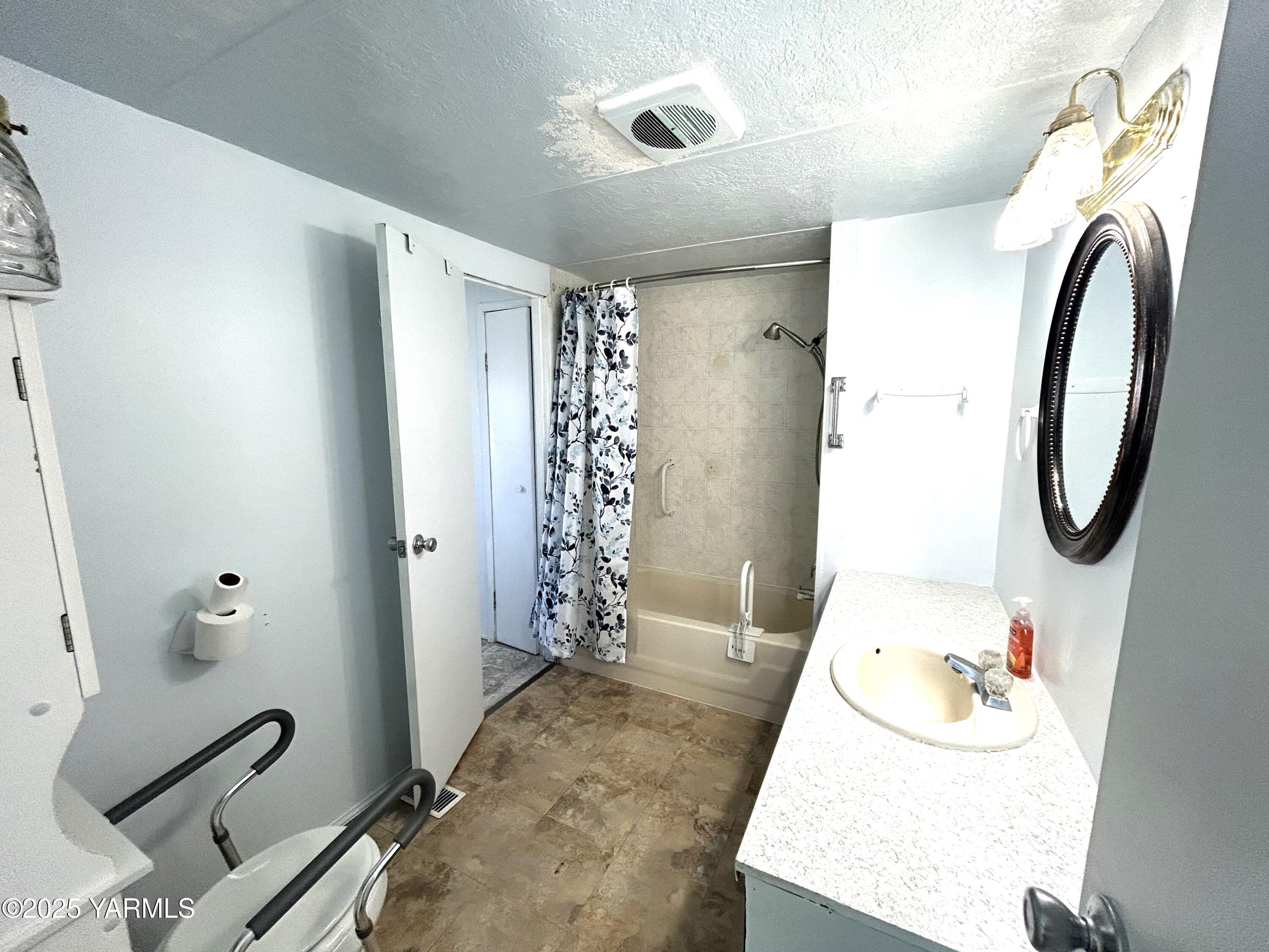 451 Pence Road, Unit 49 Yakima, WA 98908 - Photo 16 of 16 a bathroom with a granite countertop sink a toilet and shower curtain