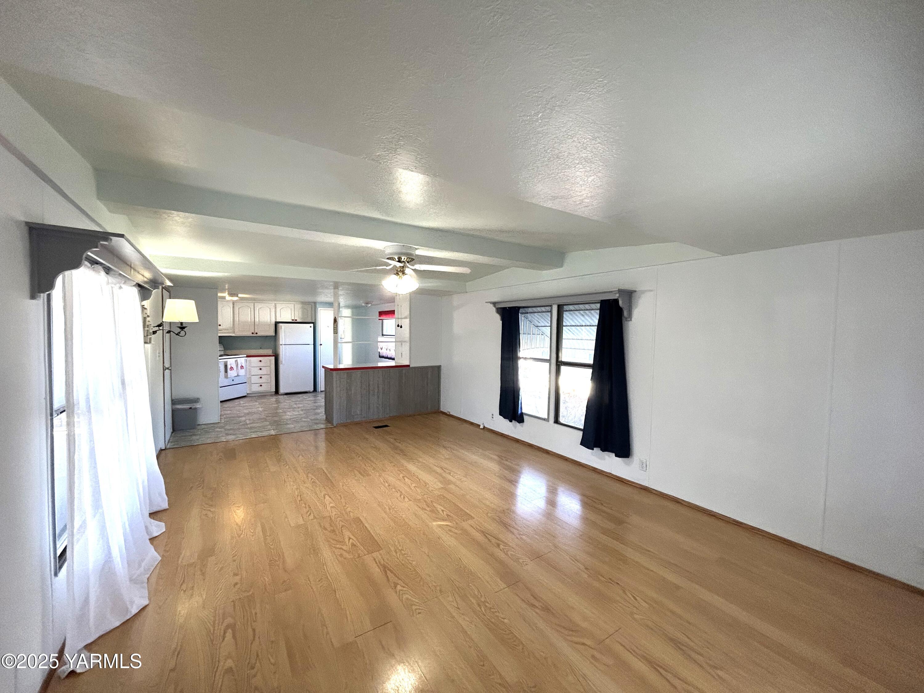 451 Pence Road, Unit 49 Yakima, WA 98908 - Photo 8 of 16 an empty room with wooden floor and windows