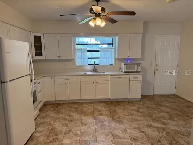 a kitchen with a sink a refrigerator and cabinets