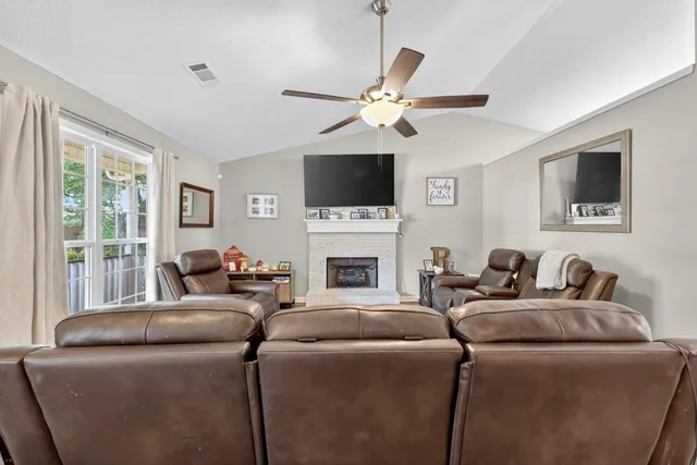 a living room with furniture a flat screen tv and a fireplace