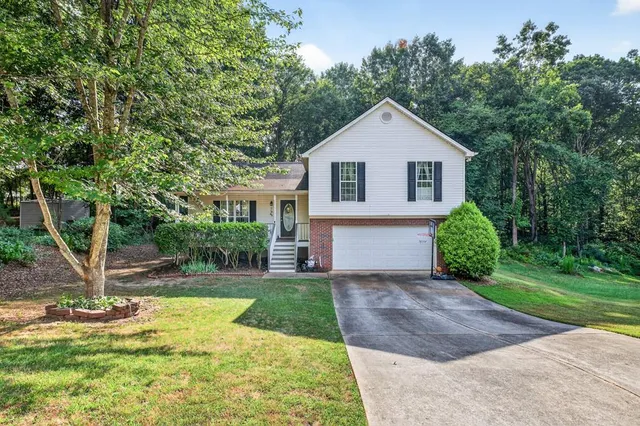 a front view of a house with yard and green space