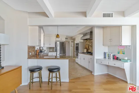 a kitchen with stainless steel appliances kitchen island granite countertop a table and chairs in it