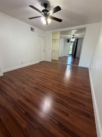 a view of empty room with wooden floor