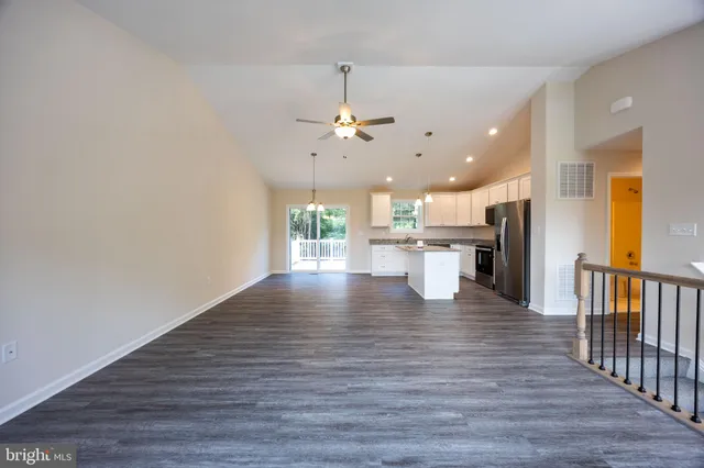 a view of kitchen with a refrigerator a ceiling fan and wooden floor