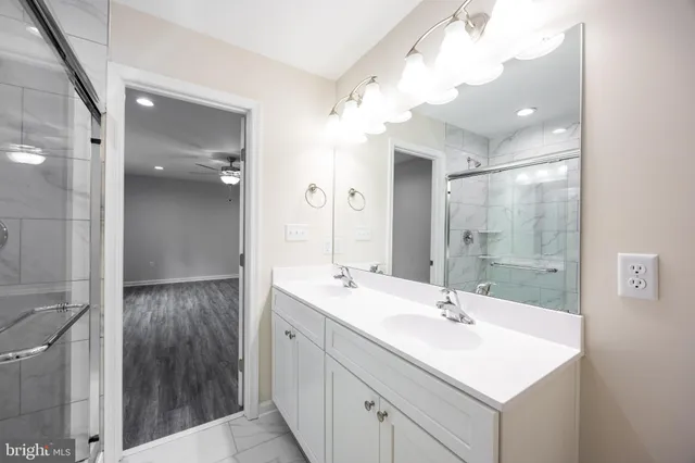 a bathroom with a sink a shower a mirror and a bathtub