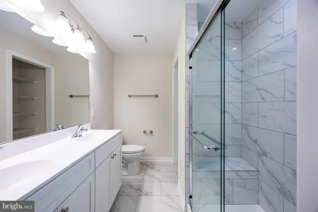 a bathroom with a double vanity sink mirror and toilet