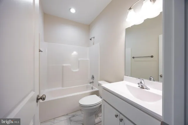 an empty room with wooden floor and ceiling fan