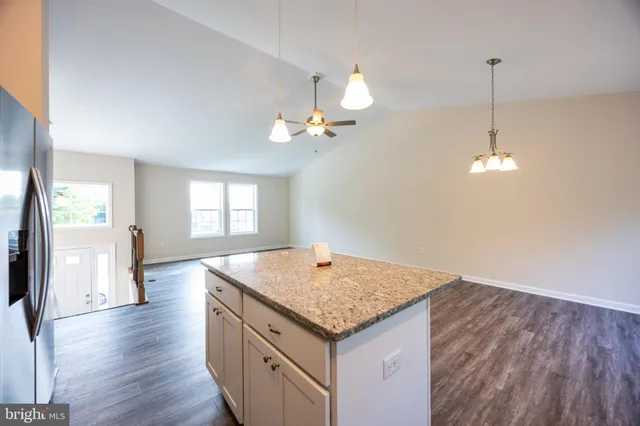 a kitchen with stainless steel appliances granite countertop cabinets a sink a dining table and chairs