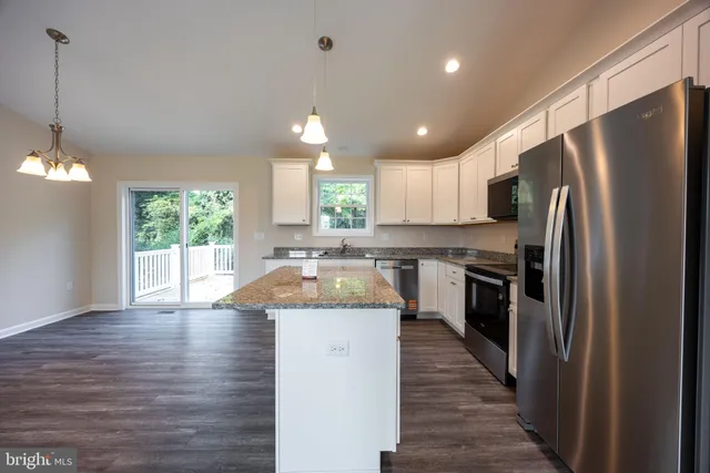 a kitchen with a refrigerator a sink dishwasher a stove and a oven with wooden floor