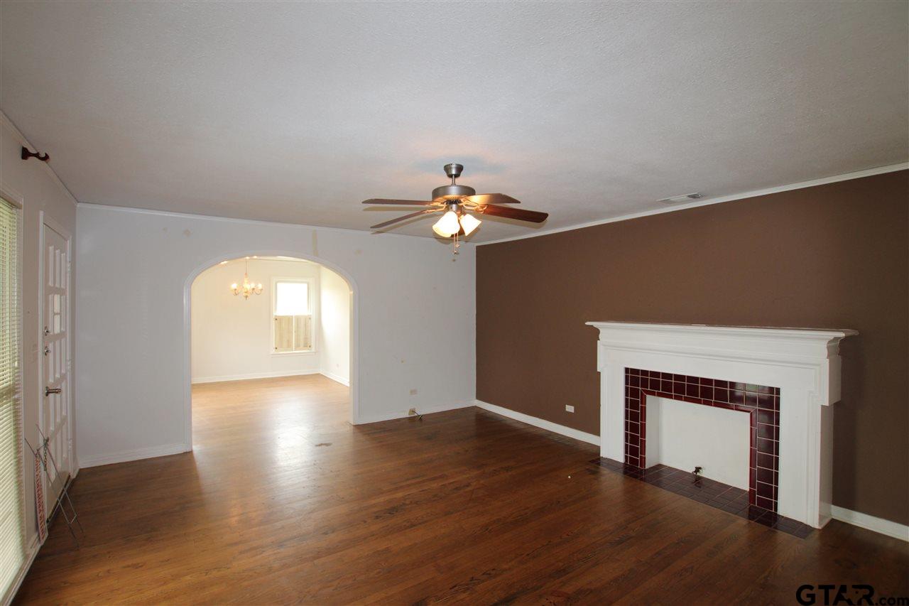 427 East 5th Street Tyler, TX 75701 - Photo 2 of 23 a view of a livingroom with a fireplace wooden floor and windows