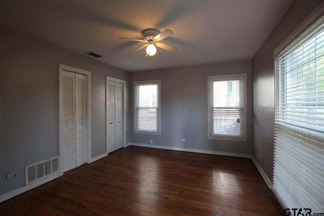 427 East 5th Street Tyler, TX 75701 - Photo 8 of 23 a view of an empty room with wooden floor and a window