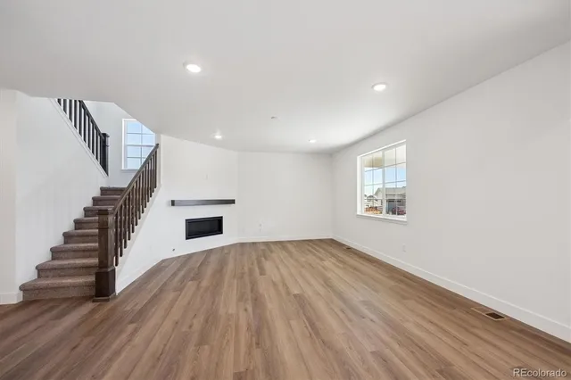 a view of a livingroom with wooden floor and stairs