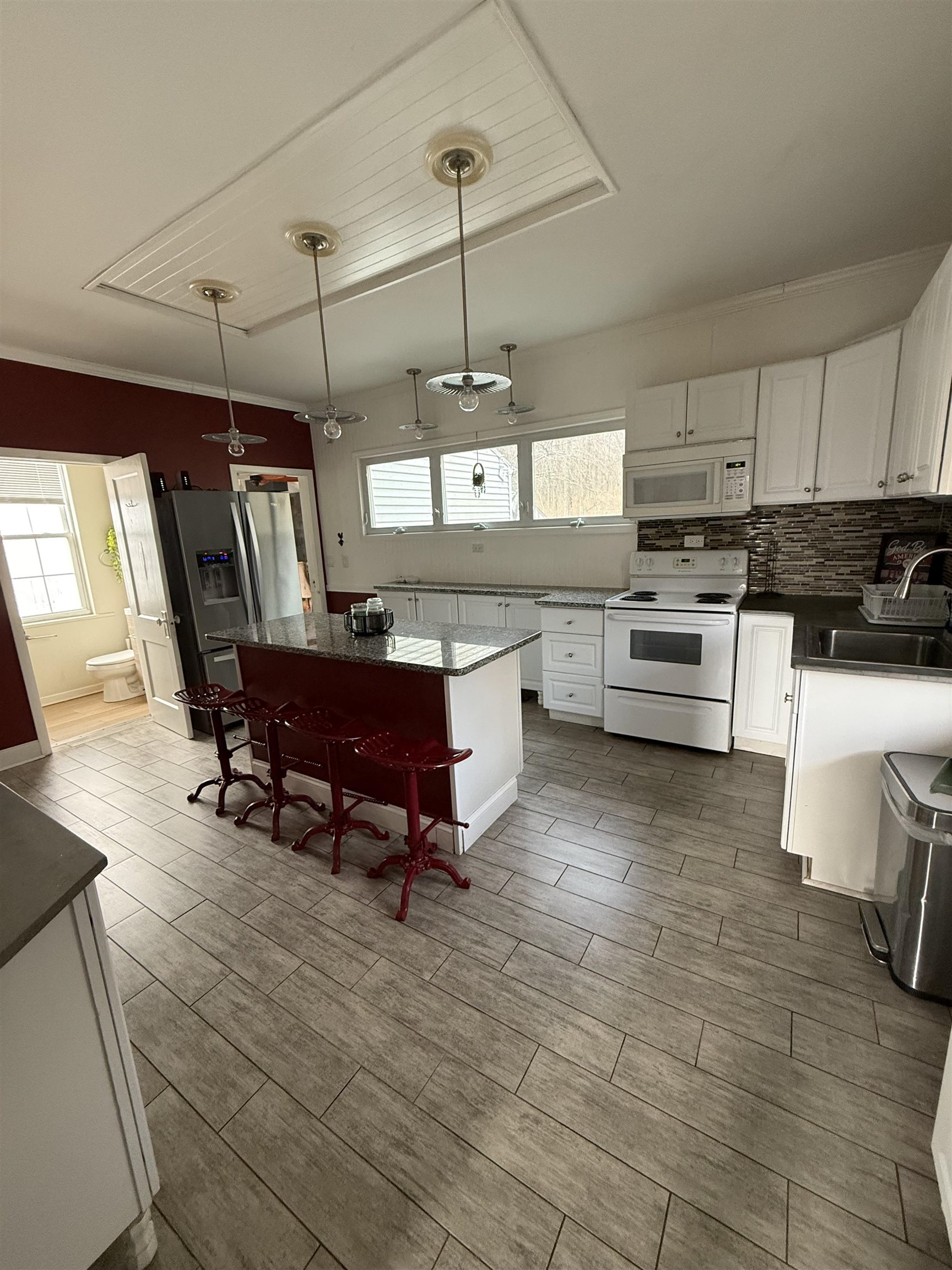 8894 North Il Route Byron, IL 61010 - Photo 3 of 13 a kitchen with stainless steel appliances granite countertop a stove a sink dishwasher a dining table and chairs with wooden floor