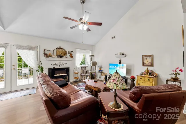 a living room with furniture a fireplace and a large window
