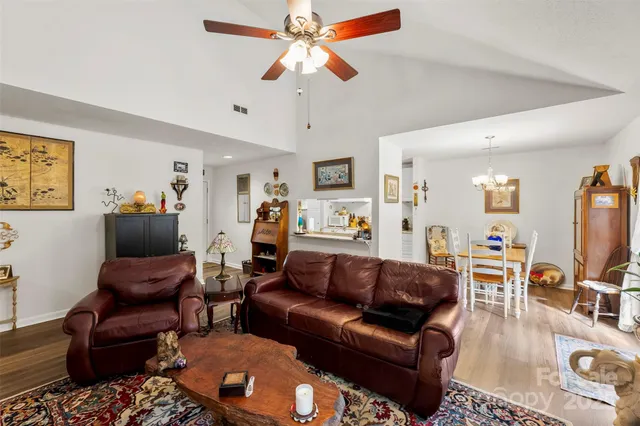 a living room with furniture a flat screen tv and a chandelier