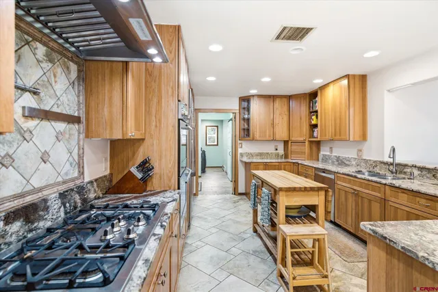 a kitchen with stainless steel appliances granite countertop a stove and a sink