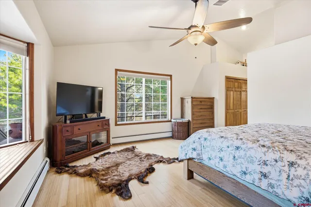 a bedroom with a bed and a flat tv screen on dresser
