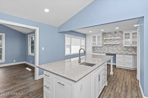 a kitchen with stainless steel appliances granite countertop a sink window and wooden floor