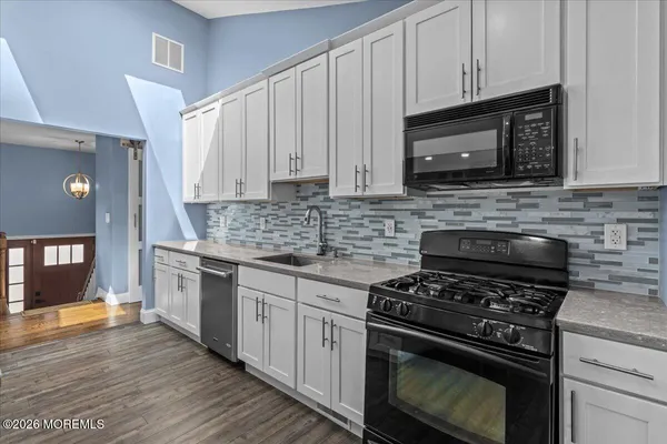 a kitchen with granite countertop a stove and a microwave