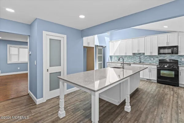 a kitchen with stainless steel appliances granite countertop a refrigerator a stove and a wooden floors