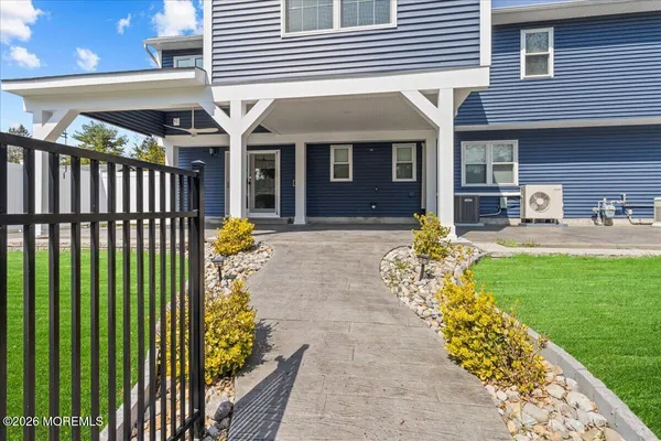 a front view of a house with a garden and plants