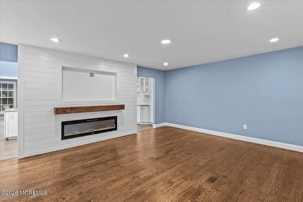a view of room with wooden floor and electronic appliances