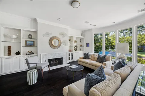a living room with furniture a fireplace and a large window