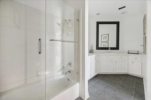 a bathroom with a bathtub a mirror a sink and vanity