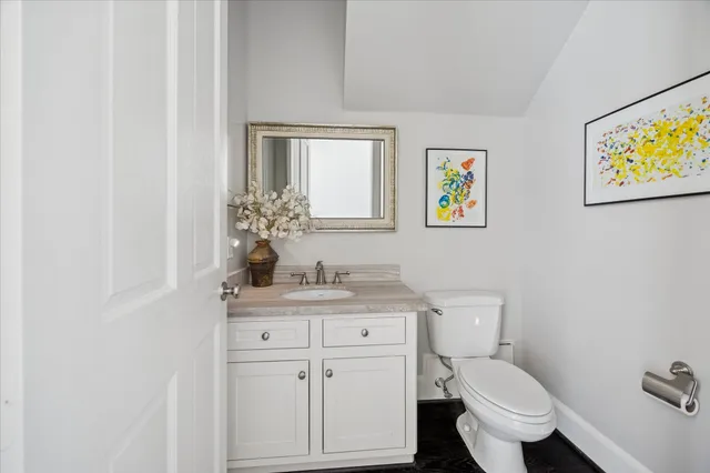 a bathroom with a granite countertop toilet sink and mirror