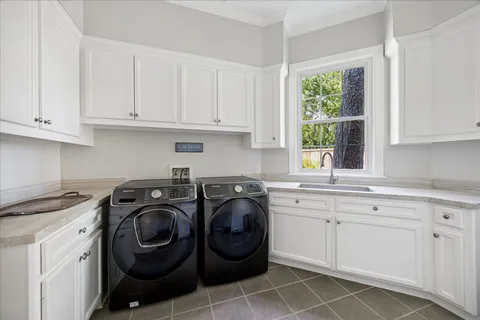 a utility room with sink dryer and washer