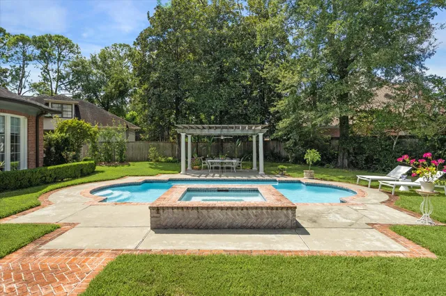 a view of swimming pool with sitting area and garden