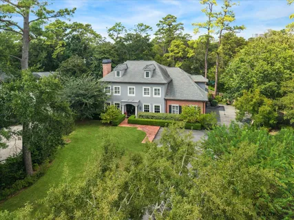 a front view of a house with a yard and fountain in middle