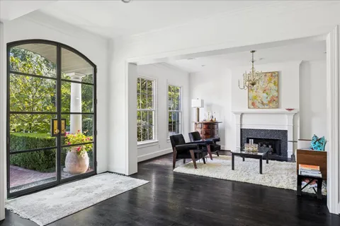 a living room with furniture a fireplace and a floor to ceiling window