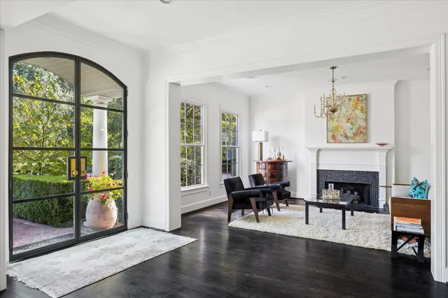 a living room with furniture a fireplace and a floor to ceiling window